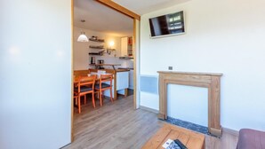 A compact living space with a dining area, kitchen, and a fireplace. - 50m from ski slopes, 2nd floor, view mountain, balcony, tv, ski locker, 27m², Montchavin La Plagne (Bellentre)