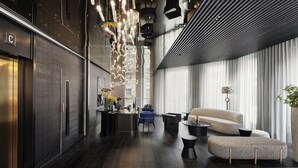 A modern hotel lobby with a reception desk, seating area, and large windows. - AMANO Covent Garden (London)
