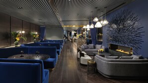 A modern lounge area with blue seating, a fireplace, and contemporary decor. - AMANO Covent Garden (London)