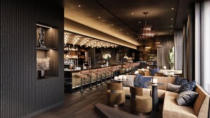 A modern bar area with a long counter, multiple stools, and a seating area with sofas and round tables. - AMANO Covent Garden (London)