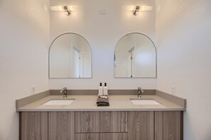 A bathroom with two sinks, a mirror, and a towel rack. - EcoView Villa•Pool•Spa•Goats•85 acres•Amazing view (Austin)