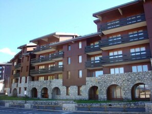 Un hôtel à plusieurs étages, doté de façades en pierre et de balcons.