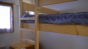 A bunk bed room with a window, a wooden desk, and a radiator. - 10m from ski slopes, floor -1, view ski slopes, balcony, 32m², Méribel-Mottaret (Méribel - Les Allues)