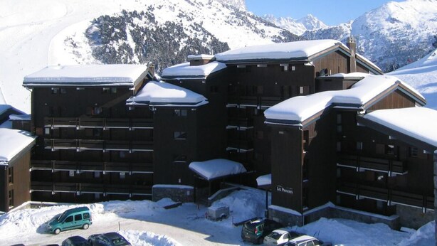 A snow-covered lodge with multiple wooden buildings, a ski lift, and a mountainous backdrop. - 10m from ski slopes, floor -1, view ski slopes, balcony, 32m², Méribel-Mottaret (Méribel - Les Allues)