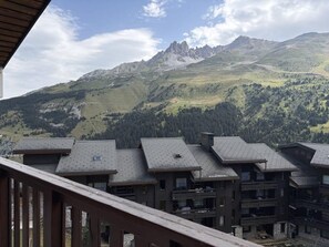 A row of chalet-style buildings with sloped roofs, set against a mountainous backdrop. - 80m from ski lifts, 5th floor, balcony, ski locker, 40m², Méribel-Mottaret (Méribel - Les Allues)