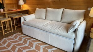 A cozy room with a beige sofa, a patterned rug, and wooden walls. - 20m from ski slopes, 8th floor, view mountain, balcony, ski locker, 32m², Méribel-Mottaret (Méribel - Les Allues)