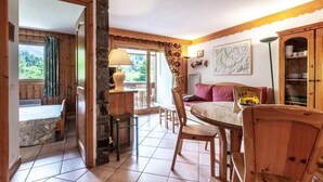 A cozy room with a dining table, chairs, a sofa, and a cabinet. - 350m from ski slopes, balcony, tv, 40m², Méribel-Mottaret (Méribel - Les Allues)