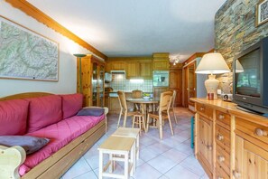 A compact living space with a sofa, dining table, chairs, a TV, and a kitchen area. - 350m from ski slopes, balcony, tv, 40m², Méribel-Mottaret (Méribel - Les Allues)