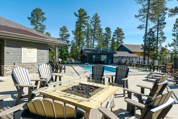 A poolside area with Adirondack chairs, a fire pit, and a building with a sign. - 4,000 Sq. Ft. New Beautiful Lodge in Powder House and Large Deck w/ View! (Lead)