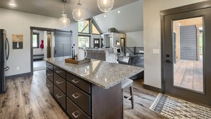 A spacious kitchen with a granite countertop, dark wooden cabinets, and pendant lighting. - 4,000 Sq. Ft. New Beautiful Lodge in Powder House and Large Deck w/ View! (Lead)