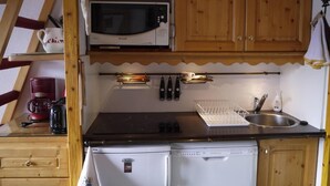 A compact kitchen with a microwave, stove, and dishwasher. - 90m from ski slopes, 3rd floor, view mountain, balcony, 27m², Méribel-Mottaret (Méribel - Les Allues)