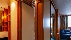 Une pièce avec une armoire en bois, une porte blanche et un canapé bleu.