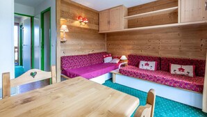 Ein gemütlicher Raum mit Holzvertäfelung, einem Holztisch und zwei Sofas mit gemusterten Bezügen.
