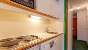 A compact kitchenette with a stove, sink, and dishwasher. - 90m from ski slopes, 4th floor, view mountain, balcony, 36m², Méribel-Mottaret (Méribel - Les Allues)