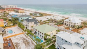 Zona residencial costera con casas, piscina y playa.