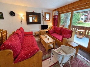 A cozy living room with a sofa set, a television, and a wooden table. - 300m from ski slopes, view parking, balcony, tv, 44m², Méribel-Mottaret (Méribel - Les Allues)
