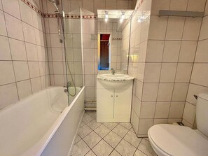 A bathroom with a bathtub, a sink, and a toilet. - 10m from ski slopes, 4th floor, balcony, tv, 17m², Les Menuires (Les Menuires)