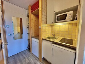 A compact kitchen with a microwave, sink, and a small refrigerator. - 10m from ski slopes, 4th floor, balcony, tv, 17m², Les Menuires (Les Menuires)
