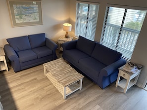 Relax in this stylish living room with a sofa, coffee table, and side table, featuring a beautiful artwork above.
