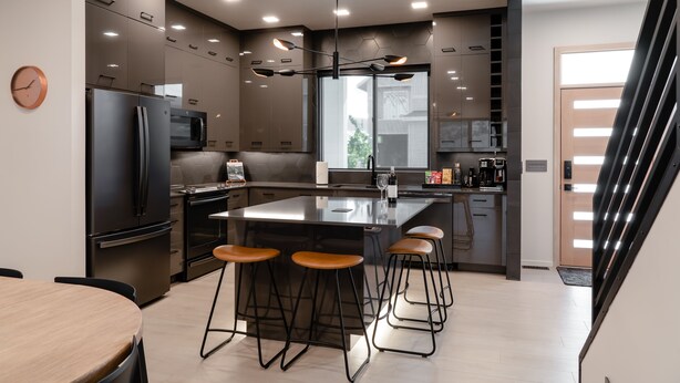 A modern kitchen with a central island, stainless steel appliances, and bar stools. - Luxury Stand Alone Condo, Minutes from Downtown Bozeman, Garage & Outdoor Patio (Bozeman)