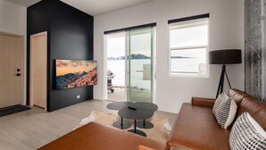 A modern living room with a large TV, a ceiling fan, and a view of the outdoors. - Luxury Stand Alone Condo, Minutes from Downtown Bozeman, Garage & Outdoor Patio (Bozeman)