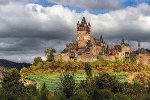 A historic castle with multiple towers, surrounded by lush greenery and vineyards. - 2bed Old Town Apt Sleeps 6 - Rooftop Terrace, Wifi (Cochem)