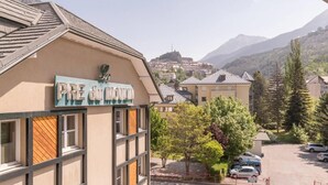 A hotel named "PRE du MOUN" with a view of a mountainous landscape in the background.