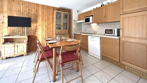A compact kitchen with wooden cabinets, a microwave, and a dishwasher. - 350m from ski slopes, 2nd floor, balcony, tv, 36m², Serre Chevalier (Briançon)