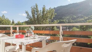 An outdoor patio with a table and chairs, a red box, and a view of a hilly landscape. - 350m from ski slopes, 2nd floor, balcony, tv, 36m², Serre Chevalier (Briançon)