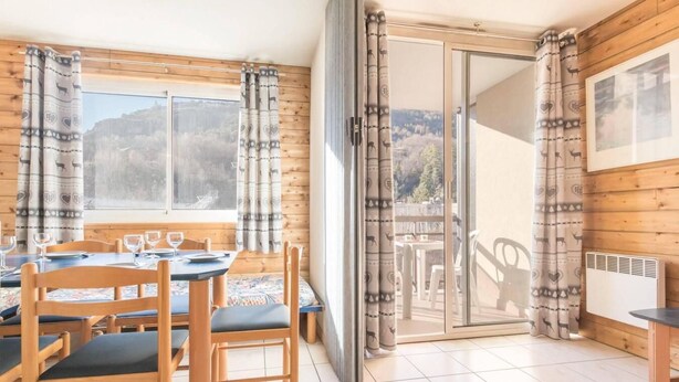Un coin repas chaleureux, avec des meubles en bois et une vue sur l’extérieur.