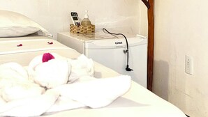 Ein Hotelzimmer mit Bett, einem kleinen Tisch mit Toilettenartikeln und Holzbalkenbauweise.