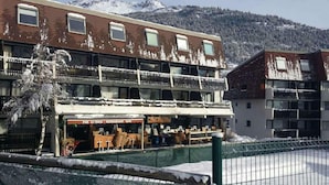 Ein Gebäude mit einem Restaurant namens "PUB LE FROG" und einem Balkon mit Außenbestuhlung.