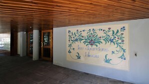 Ein Korridor mit Holzboden und einer Wand mit floralem Dekor und französischem Text.