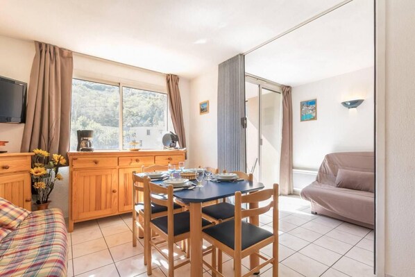 Relax in this spacious living area with a dining table for four, flat-screen TV, and comfortable sofa.