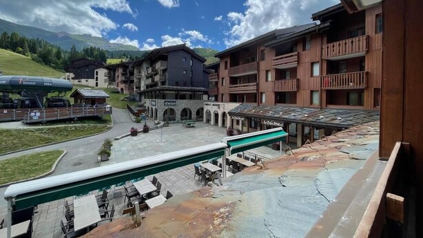 A hotel courtyard with outdoor seating, a ski lift, and buildings with balconies. - 300m from resort center, 2nd floor, view ski slopes, balcony, tv, ski locker, 27m², Valmorel (Valmorel)