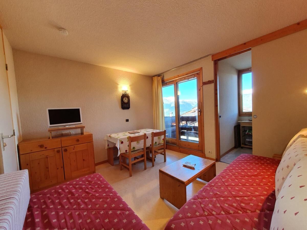 Une chambre confortable avec deux lits, une télévision, une table et des chaises.