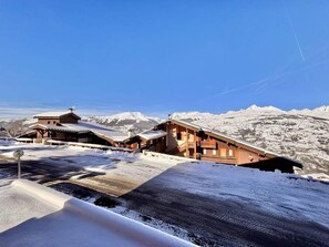 A wooden chalet with a sloped roof, surrounded by snow-covered mountains. - 80m from ski slopes, 1st floor, view mountain, balcony, tv, ski locker, 26m², Montchavin La Plagne (La Plagne)