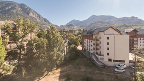 A mountain town with a mix of modern and traditional buildings, a clear sky, and a view of the surrounding mountains.
