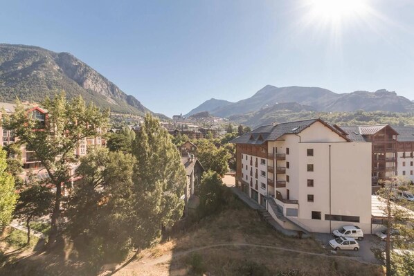 A mountain town with a mix of modern and traditional buildings, a clear sky, and a view of the surrounding mountains. - 150m from ski slopes, 6th floor, view mountain, balcony, tv, 47m², Serre Chevalier (Briançon)
