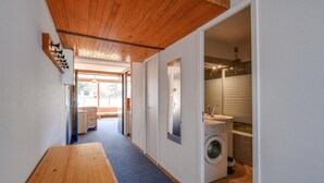 A narrow hallway with a wooden bench, a washing machine, and a bathroom with a shower and sink. - 50m from ski slopes, 7th floor, balcony, tv, 60m², Les Arcs (Les Arcs)