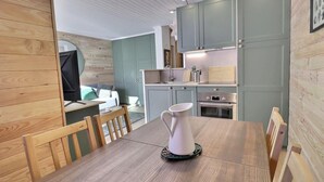 A compact kitchen with a dining area, wooden walls, and a modern design. - 10m from ski slopes, 1st floor, balcony, 35m², Méribel-Mottaret (Méribel - Les Allues)
