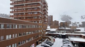 En byggnad med flera våningar och en parkeringsplats framför.