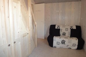 Enter a room with a wooden door and a comfortable chair, set against a backdrop of a tiled floor and a wall featuring a wooden panel design.