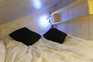 Cozy retreat with a single bed, wooden paneling, and a light fixture.
