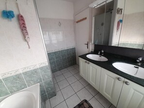 A bathroom with two sinks, a mirror, and a shower. - city break  (Coudekerque-Branche)