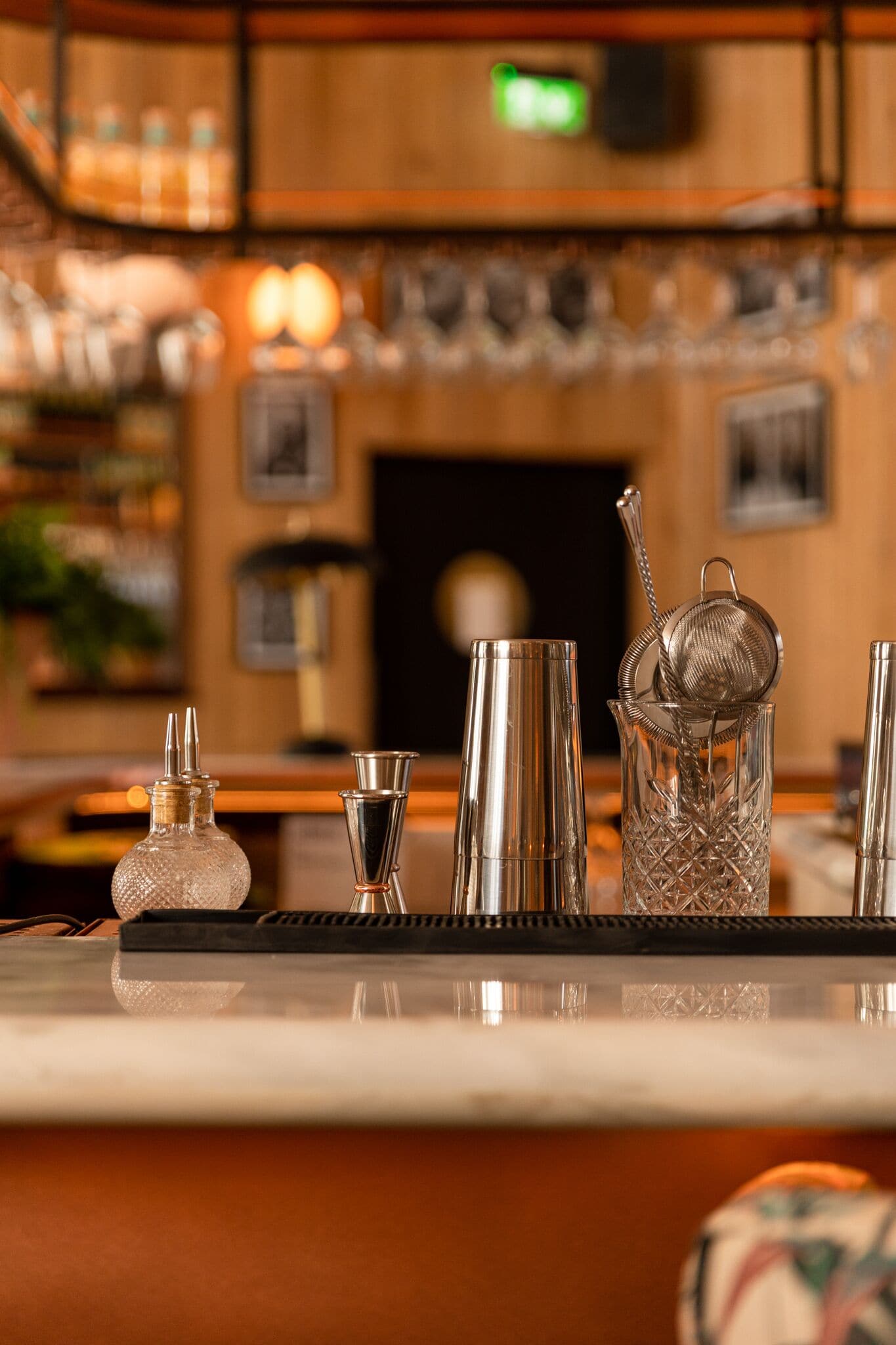 Eine Bar mit unterschiedlichem Glaswerk und einem Metallsieb auf der Theke.