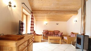 A cozy living room with wooden furniture, a fireplace, and a television. - 100m from ski slopes, 1st floor, balcony, fireplace or stove, tv, ski locker, 90m², Val Cenis (Lanslebourg-Mont-Cenis)