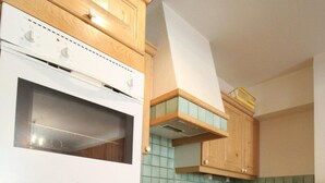 Et køkken med træskabe, en hvid komfur og et backsplash med grønne fliser.