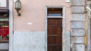 A building with a wooden door, a street lamp, and a sign with the number 147.