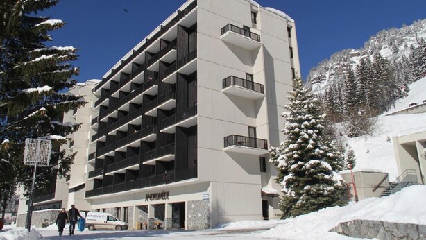 A multi-story hotel with a modern architectural design, featuring balconies on each floor and a snow-covered landscape in the background. - 2nd floor, balcony, tv, ski locker, 25m², Flaine (Flaine)